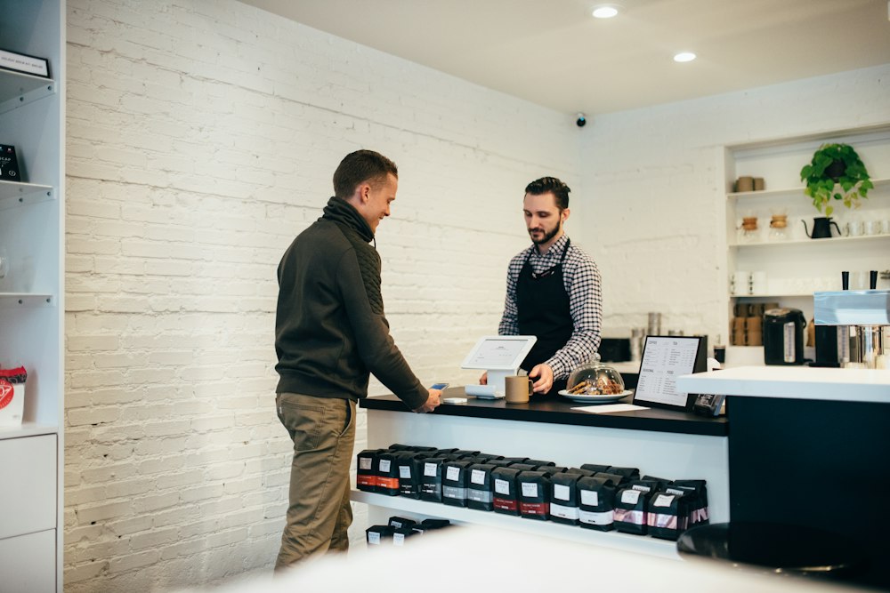 A shop owner talking with a customer at the counter